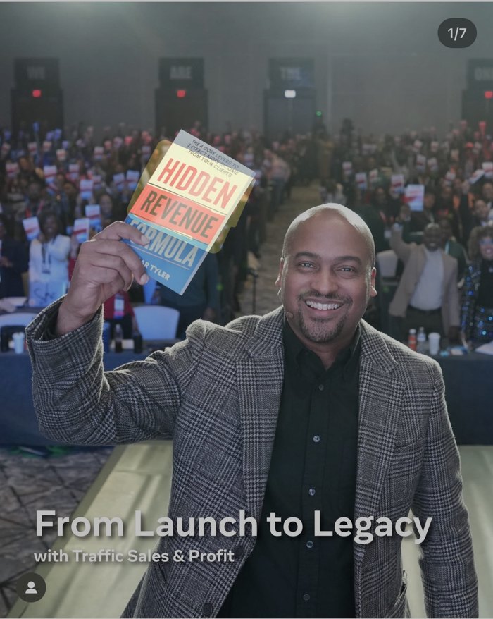 Lamar Tyler on stage holding Hidden Revenue Formula before a large audience